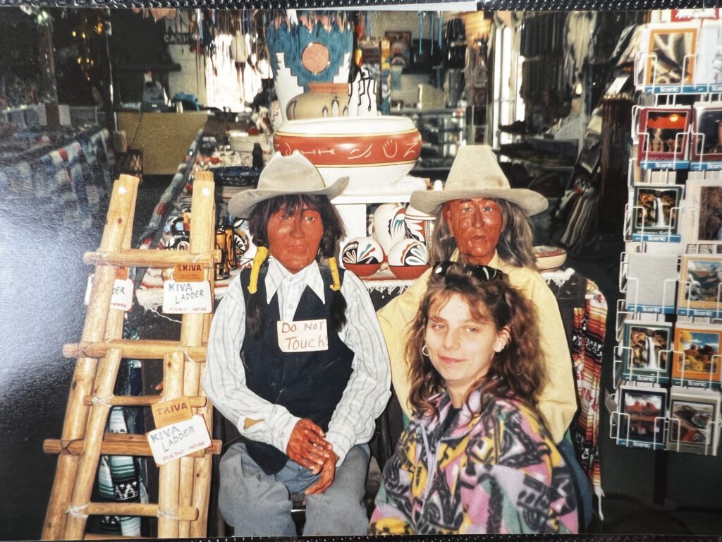 Hier sitze ich in einem Laden in New Mexico vor 2 Navajo-Puppen. Im Hintergrund Produkte der Navajos, die man kaufen konnte.